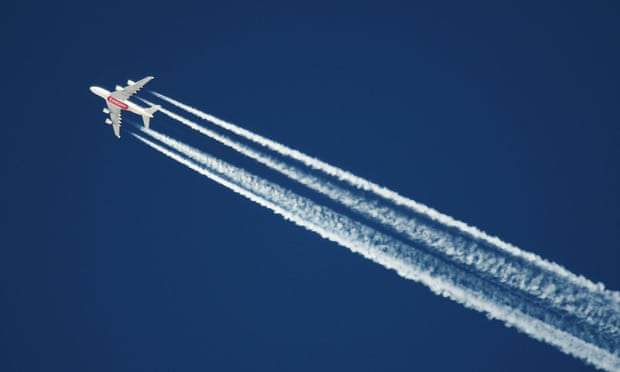 Plane flying, its emissions visible