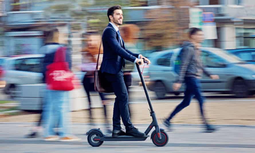 Businessman riding electric scooter in the city
