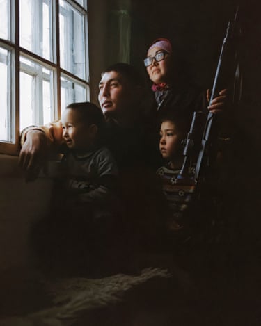 Ruslan (35) with his wife and two kids. Ruslan started hunting when he was a teen and now travels around the country shooting wolves for villages suffering from attacks. He is paid in sheep or horses for his work. Ottuk, Kyrgyzstan. February, 2021.