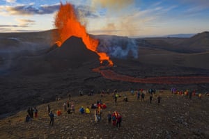 Les gens regardent la lave s'écouler du volcan Fagradalsfjall sur la péninsule de Reykjanes, dans le sud-ouest de l'Islande.