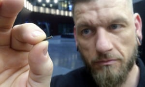 Jowan Osterlund from Biohax Sweden holds a small microchip implant, similar to those implanted into volunteers at the Australian Centre for the Moving Image