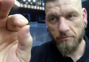 In this March 14, 2017, file photo, Jowan Osterlund from Biohax Sweden, holds a small microchip implant, similar to those implanted into workers at the Epicenter digital innovation business center during a party at the co-working space in central Stockholm. Three Square Market in River Falls, Wis., is partnering with Sweden’s BioHax International, offering to microchip its employees, enabling them to open doors, log onto their computers and purchase break room snacks with a simple swipe of the hand.
