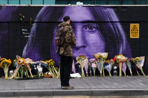 Floral tributes in front of a Black Sabbath mural