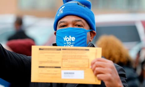 A voter holds his sealed ballot on 25 October 2020 in Detroit, Michigan.