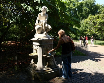 A woman fills a bottle at a public water fountain in St James’ Park in London