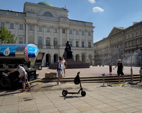 A municipal drinking-water tank and a water misting sprayer operate near the Mikołaj Kopernik Monument on Krakowskie Przedmieście in Warsaw, Poland.