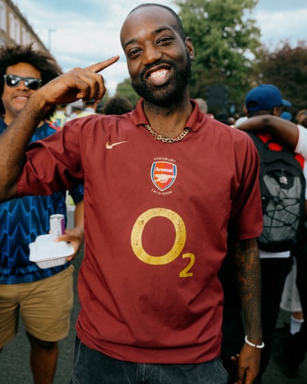 A man with a beard wearing a vintage maroon Arsenal football shirt from 2006