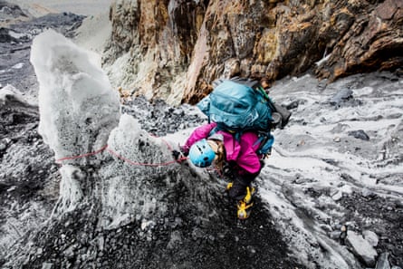 A climber shot from above looking down in concentration on snow and grey rocks