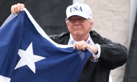 Donald Trump holds the state flag of Texas outside of the Annaville fire house in Corpus Christi, Texas.