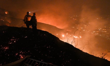 Firefighters look out over a burning hillside as they fight the Blue Ridge Fire in Yorba Linda, California, 2020.