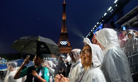 Fans wait in the rain at the Trocadero, next to the Eiffel Tower, for the opening ceremony finale.