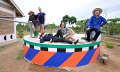 Graphic artist Camille Walala and her collaborator Julia Jomaa sit alongside residents of Ukerewe on a brightly coloured water towe