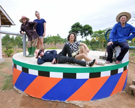 Graphic artist Camille Walala and her collaborator Julia Jomaa sit alongside residents of Ukerewe on a brightly coloured water towe
