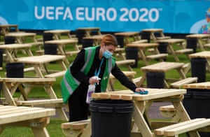 Justine Ralston cleans tables as finishing preparations are made to the UEFA EURO 2020 Fan Zone at Glasgow Green.