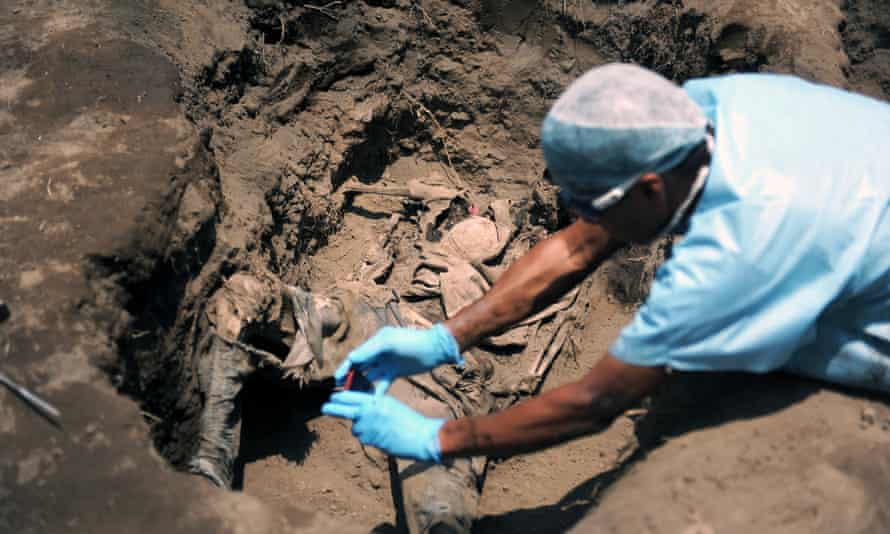 Israel Ticas taking photographs of the remains of an unidentified woman in Colon, 20km west of San Salvador.