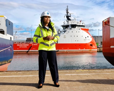 Kemi Badenoch standing in a port.