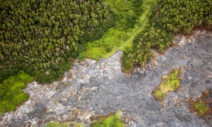 An aerial view of the lava flow front covering a dirt road