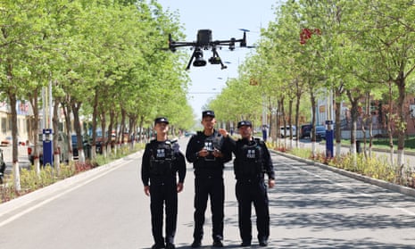 Police officers use a drone to patrol a street in Altay, Xinjiang province.