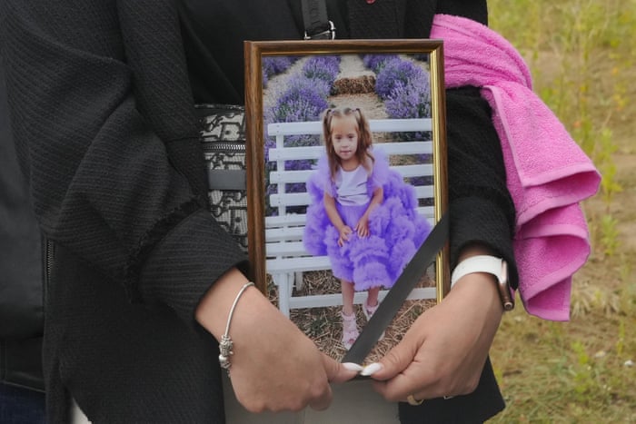 A woman carries a portrait of Liza, a four-year-old girl killed in a Russian attack, during a funeral ceremony in Vinnytsia, Ukraine