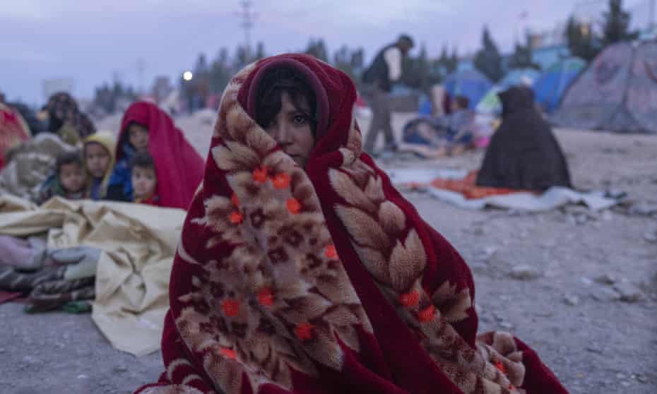 An Afghan woman and her family camped outside the Directorate of Disaster office in Herat, Afghanistan.