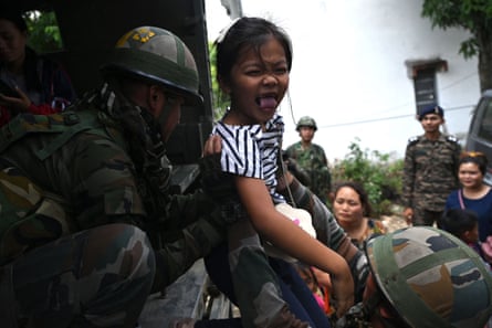 Indian soldiers help evacuate a girl during the ethnic riots in Manipur state.