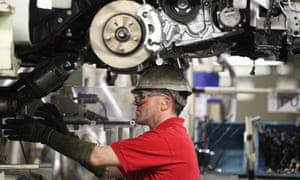 A Toyota worker assembles a vehicle on the production line in Burnaston.