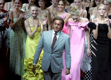Valentino stands in front of a group of models who are applauding him
