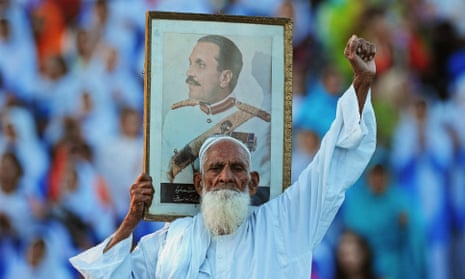 A Pakistani man holds a picture of former president of Pakistan, General Zia-ul-Haq, at the Wagah border near Lahore, 2010.