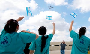 The Israeli medical teams of Sheba Medical Center, greet with their flags the passage of the voltage team of the Israeli Air Force above the hospital during the festivities of the day Independence of Israel (Yom Ha’atzmaut) on April 29, 2020 in Ramat Gan.
