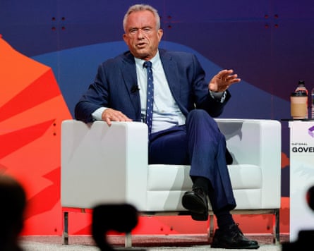 Robert F Kennedy Jr in a suit sitting in an armchair on a stage