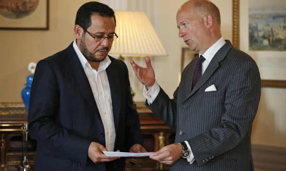 Dominick Chilcott, right, Britain’s ambassador to Turkey, hands over a letter of apology from the UK government to Abdel Hakim Belhaj.