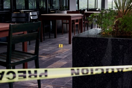 An evidence marker is placed next to blood stains at a hotel restaurant where Nadia Beller was shot by a man dressed as a delivery rider.