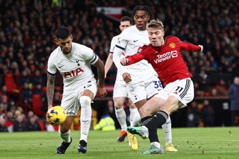 Manchester United's Danish striker Rasmus Hojlund (R) shoots to score.