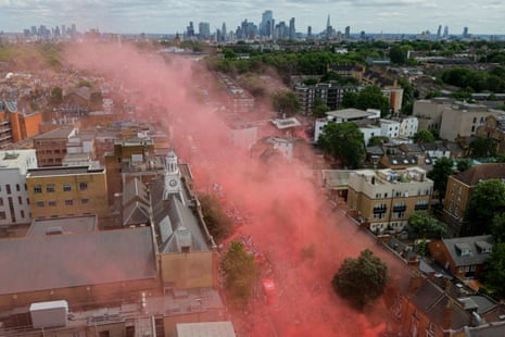 Red smoke drifts above the Holloway Road.
