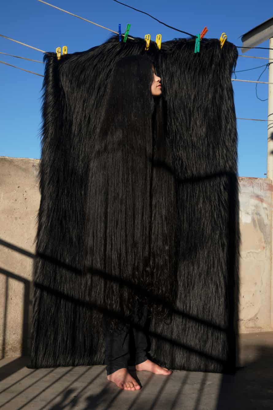 Antonella Bordon disappearing in front of some black faux fur on a washing line on the roof of the building where she lives