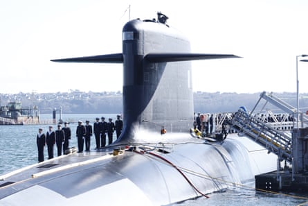 Members of the French navy stand to attention on top of the submarine