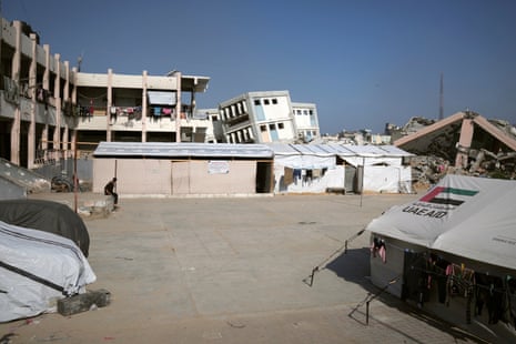 Children are receiving education in Gaza surrounded by buildings destroyed by Israeli bombardment.