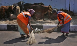 Indian civic workers sweep a road in Hyderabad, India.