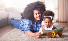 Mother reading a book to her daughter on carpet<br>family, carpet, book, reading, hone