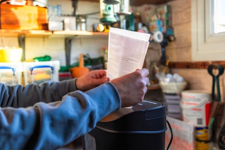 A person putting paper into a shredder