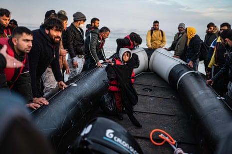 Migrants move a smuggling boat into the water, Gravelines, France