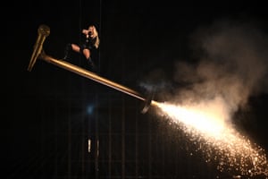 Erika Vikman rides a giant microphone that hangs from the roof and has a firework shooting from its base