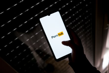 hand holds phone displaying PornHub logo