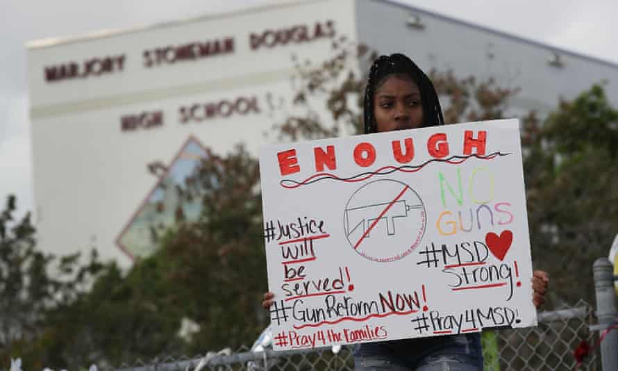 Tyra Heman, a senior at Marjory Stoneman Douglas High School, holds a sign that reads ‘Enough’.