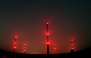<strong>Gemuend, Germany</strong> A long exposure image shows a meteor streaking across the night sky over illuminated wind generators