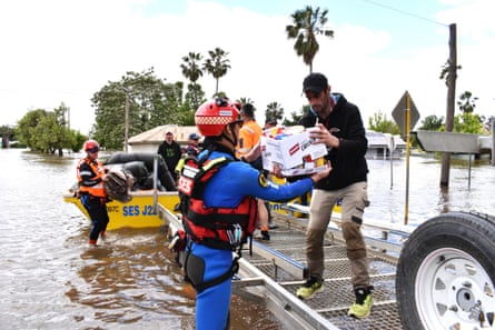 A rescue worker handing a man a box of food