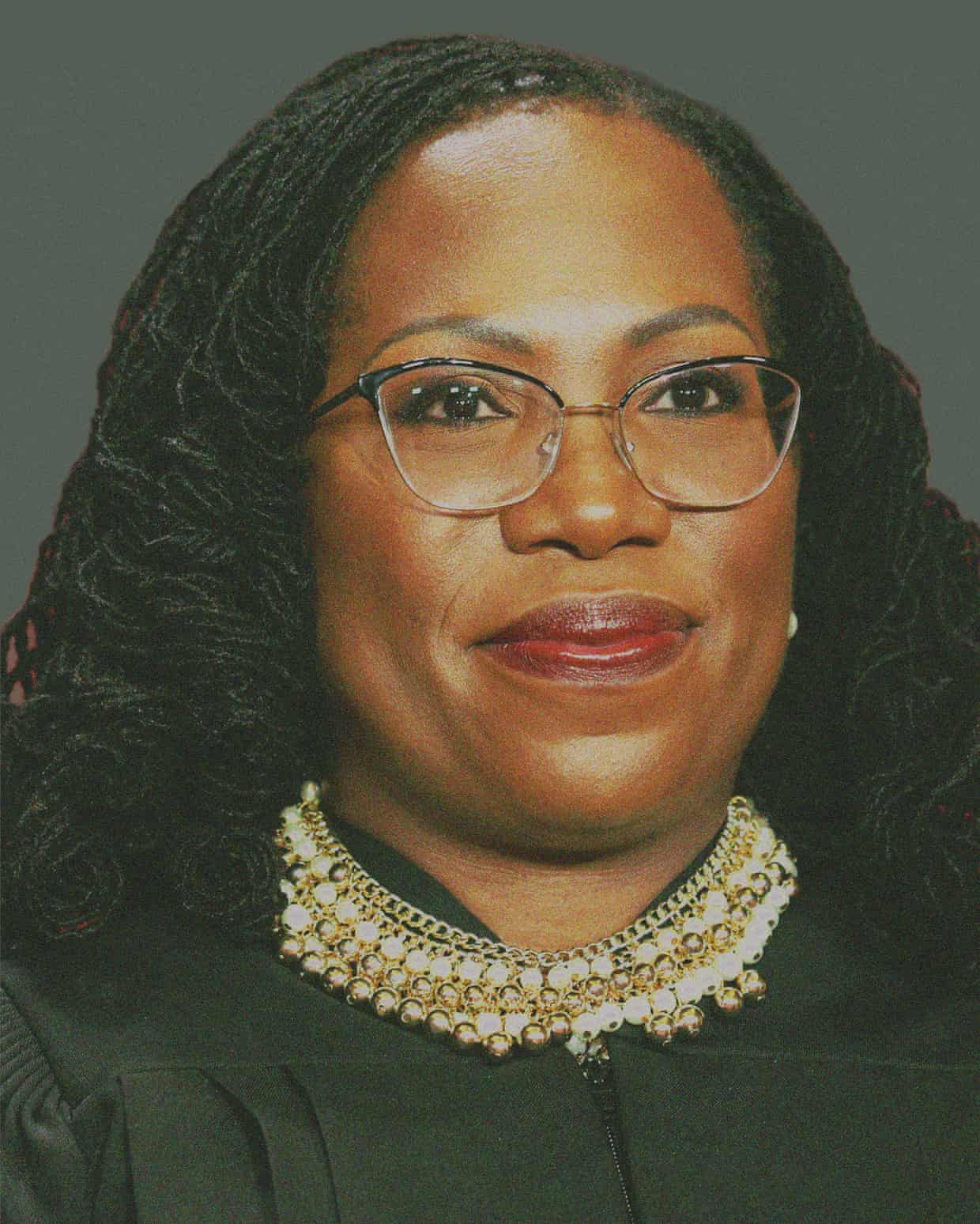 A smiling woman wearing glasses and a beaded necklace