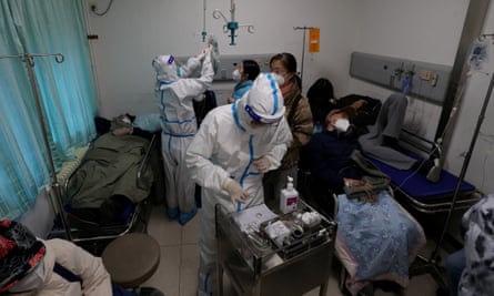 Medical workers in protective suits attend to patients at a fever clinic at a hospital in Beijing.