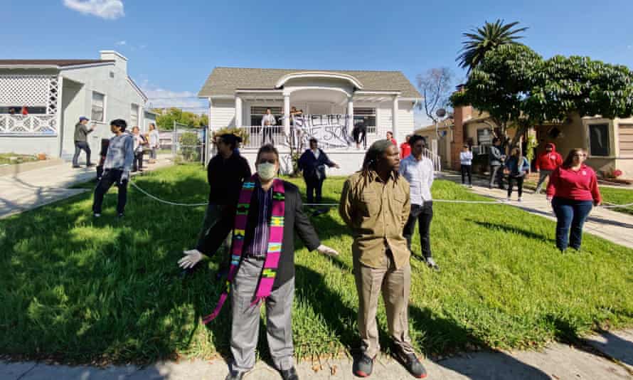 Members of Reclaiming Our Homes stand guard on the first day of a home takeover in LA.
