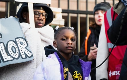 A child looks on as she stands around protesters
